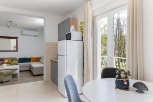 uma cozinha e sala de estar com um frigorífico branco em Stephanie green island apartments em Šipanska Luka