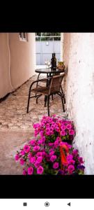 uma mesa e um ramo de flores cor-de-rosa ao lado de uma mesa em Studio ADA em Mostar
