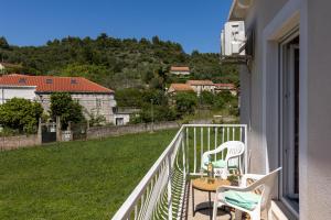 a balcony with two chairs and a table at Stephanie green island apartments in Šipanska Luka