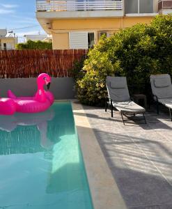 un flotteur de flamants roses dans une piscine dans l'établissement CreteSuites - Urban Villa with Pool - 500m to the Beach, à Réthymnon