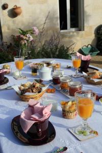 una mesa con comida y bebida y tazones de comida en Les charmes de Vincent - le loft Cabernet, en Fronsac