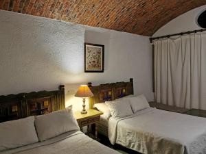 1 dormitorio con 2 camas y mesa con lámpara en Suite linda vista, en San Miguel de Allende