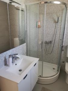 a bathroom with a sink and a shower at Žuta kuća in Grude