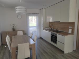 a kitchen with a table and a kitchen with white cabinets at Žuta kuća in Grude