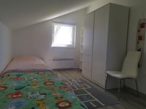 1 dormitorio con 1 cama, 1 silla y 1 ventana en Žuta kuća, en Grude