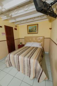 una camera da letto con un letto con una coperta a righe di Residencial San Felipe a Lima
