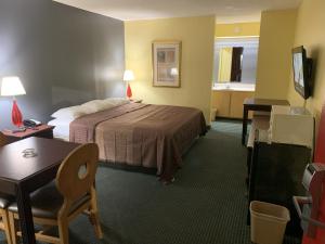 ダブリンにあるRelax Inn & Suitesのベッドとデスクが備わるホテルルームです。