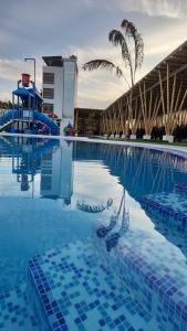 a swimming pool with a water slide and palm trees at Hotel Gran Marquez in Moquegua