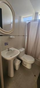 uma casa de banho com um lavatório, um WC e um espelho. em Hotel Gran Marquez em Moquegua