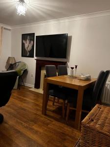 a dining room with a table and a flat screen tv at ROOM ONLY- option of the entire house if available - private property in quiet estate in Nottingham