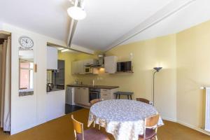 eine Küche und ein Esszimmer mit einem Tisch und Stühlen in der Unterkunft La Mongie studio 4adultes 2enfants et terrasse in Bagnères-de-Bigorre