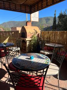 d'une terrasse avec des tables, des chaises et un four à pizza. dans l'établissement Tazart Lodge, à Marrakech