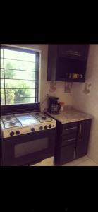 a small kitchen with a stove and a window at Casa La Prieta Linda in Tamasopo