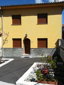 ein gelbes Gebäude mit braunen Fenstern und Blumen davor in der Unterkunft Vivienda Vacacional Alba Marinas in Pravia