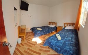 a room with two beds and a television in it at Starfish of Paracas in Paracas