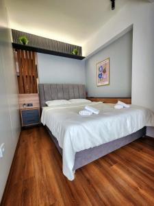 a bedroom with a large bed with white sheets at District Apartment in Bitola