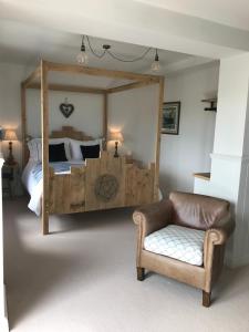a bedroom with a large bed and a chair at Mevagissey Boutique Flatlet with sea and countryside views in Mevagissey