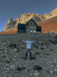 a person standing in front of a cabin at Puesto Cagliero - Refugio de montaña in El Chalten