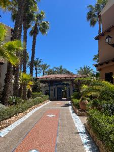 a driveway leading to a building with palm trees at Casa al mare Aldea in Torrevieja