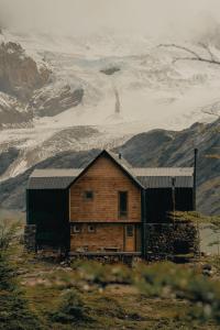 una cabaña de madera en medio de una montaña en Puesto Cagliero - Refugio de montaña en El Chaltén