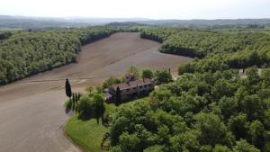 eine Luftansicht eines Hauses und eines Feldes in der Unterkunft Agriturismo Chieteno con piscina - Cetona in Cetona