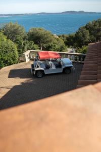 Villa prestige (voiture plage) في كاركيران: سيارة قولف مع سقف احمر متوقفة على الفناء