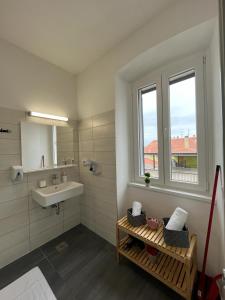 uma casa de banho branca com um lavatório e uma janela em Apartment Arena em Pula