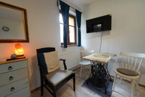 a room with a table and a chair and a television at Garsonka u pivovaru, centrum Rožnov in Rožnov pod Radhoštěm