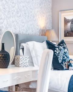 a bedroom with a bed with pillows and a mirror at Ironbridge View Townhouse - Stunning view of the Iron Bridge UK WINNER 2024 'MOST PICTURESQUE SELF-CATERING HOLIDAY HOME' of the year' & WINNER '2024 BEST HOLIDAY HOME IN SHROPSHIRE' in Ironbridge