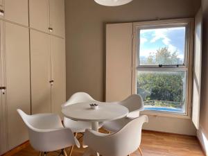 een witte tafel en stoelen in een kamer met een raam bij Departamento familiar in Coronel Suárez