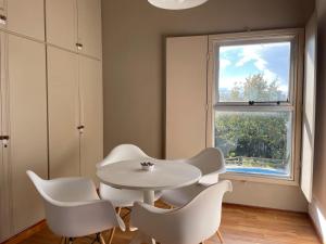 a white table and chairs in a room with a window at Departamento familiar in Coronel Suárez +6 photos