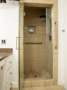 a shower with a glass door in a bathroom at Gallery Guest in Fayetteville