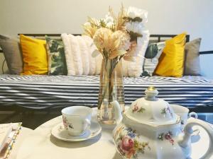a table with a tea set and a vase with flowers at Spacious Stylish Private 2-Bedroom Home in Barrie