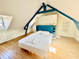 a bedroom with a white bed in a attic at Les hirondelles de Deauville in Deauville