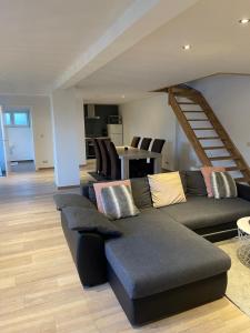 a living room with a couch and a staircase at Hele mooie vakantiewoning nabij Brugge in Damme