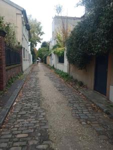 eine Kopfsteinpflasterstraße in einer Gasse zwischen Gebäuden in der Unterkunft Le charles in Paris