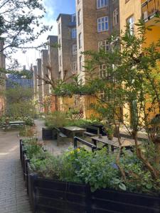 a garden with tables and plants in front of buildings at Globetrotter Hotel in Copenhagen