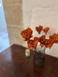 姆迪納的住宿－'Notabile' - Private Townhouse in Mdina，摆在桌子上的花瓶,上面装满了橙花