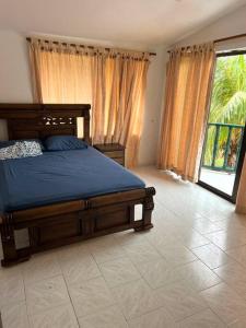 een slaapkamer met een bed en een groot raam bij Cabaña Con Piscina Frente Al Mar in Juan de Acosta