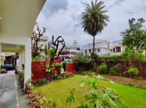 um quintal de uma casa com um relvado verde em Boho Heritage Stays Udaipur em Udaipur