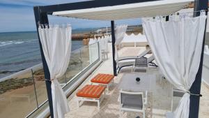uma varanda com cadeiras e vista para o oceano em Dar Jean em Asilah
