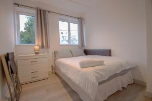 a bedroom with a bed and a dresser and a window at Modern Spacious 4-Bed House in London