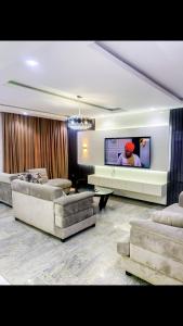 ein Wohnzimmer mit Sofas und einem Flachbild-TV in der Unterkunft 60B Adetoun Adelaja 4Bedroom in Lagos