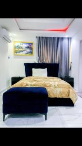 a bedroom with a large bed and a blue ottoman at 60B Adetoun Adelaja 4Bedroom in Lagos