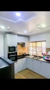 eine Küche mit weißen Schränken und einem Herd mit Backofen in der Unterkunft 60B Adetoun Adelaja 4Bedroom in Lagos
