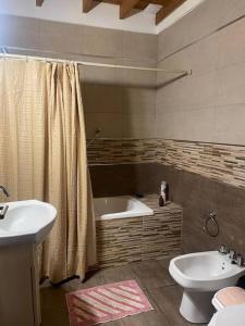 uma casa de banho com uma banheira, um WC e um lavatório. em Casa Vivienda Familiar Ituzaingo Centro Parque em Ituzaingó