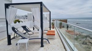 a balcony with chairs and a view of the ocean at Dar Jean in Asilah