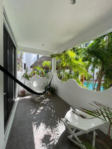 uma varanda com cadeiras e plantas numa casa em Amaranta Beach em Playa del Carmen