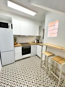uma cozinha com armários brancos e um piso xadrez em Acogedor apartamento enfrente de la catedral em Tarragona