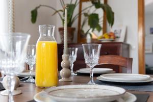 una mesa con una botella de zumo de naranja y platos y vasos en Johnny's Casa, en Vila do Bispo